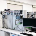 Rack de servidores ao lado de uma estação de trabalho em um ambiente corporativo de tecnologia