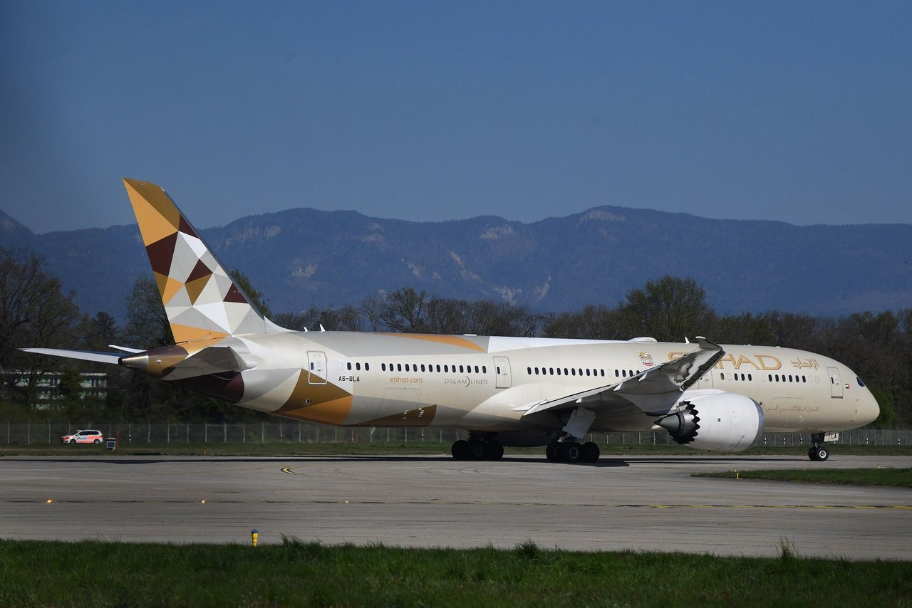 Avião da Etihad Airways taxiando em uma pista de aeroporto sob céu claro.